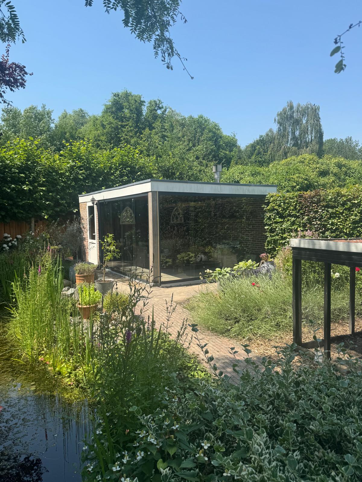 Glazen schuifwand in modern tuinverblijf midden in groene tuin